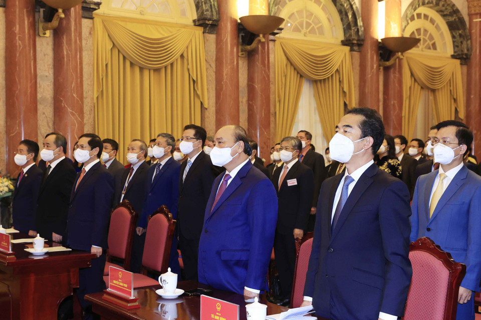 Chiều 14/12/2021, tại Phủ Chủ tịch, Chủ tịch nước Nguyễn Xuân Phúc trao Quyết định phong hàm Đại sứ và gặp mặt các đại sứ, trưởng cơ quan đại diện Việt Nam tại nước ngoài nhân dịp về dự Hội nghị Đối ngoại toàn quốc, Hội nghị Ngoại giao 31 và Hội nghị Ngoại vụ toàn quốc lần thứ 20. Trong ảnh: Chủ tịch nước Nguyễn Xuân Phúc và các đại biểu thực hiện nghi lễ chào cờ. (Ảnh: Thống Nhất/TTXVN)