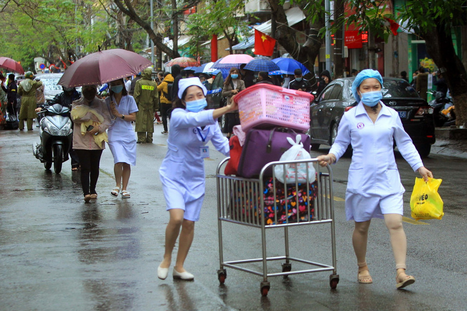 Các bác sỹ giúp bệnh nhân xuất viện ngày sau khi được bệnh viện gỡ bỏ phong tỏa. (Ảnh: An Đăng/TTXVN)