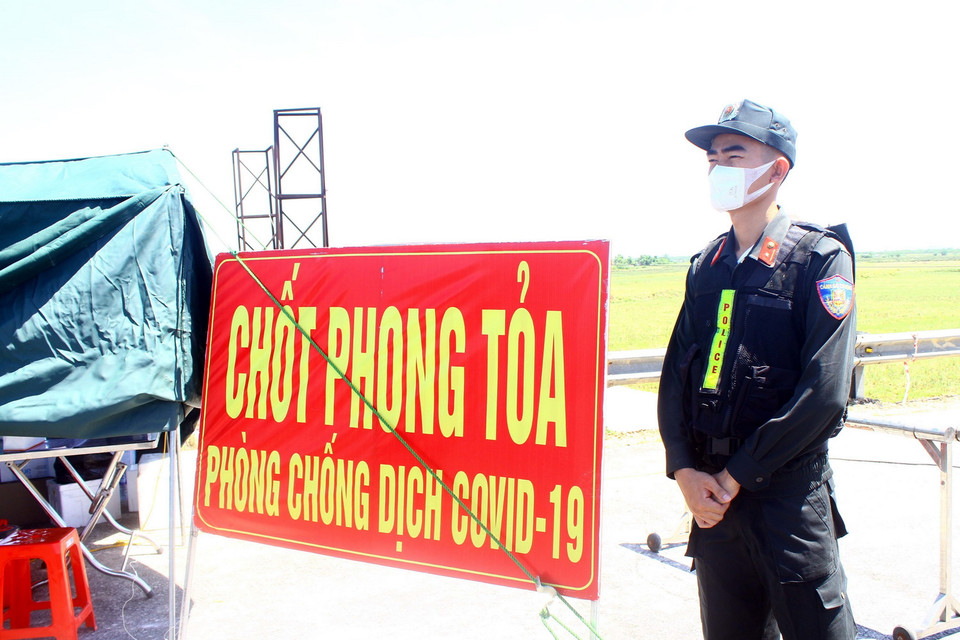 Thiếu úy Trần Hải Hoàn, Phòng cảnh sát cơ động Công an tỉnh Nghệ An, bất chấp nắng nóng để bám chốt tại đê xã Hưng Hòa, kiểm soát chặt người và phương tiện. (Ảnh: Tá Chuyên/TTXVN)