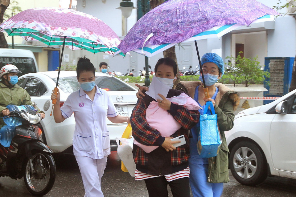 Các y bác sỹ giúp bệnh nhân xuất viện ngày sau khi được gỡ bỏ phong tỏa. (Ảnh: An Đăng/TTXVN)