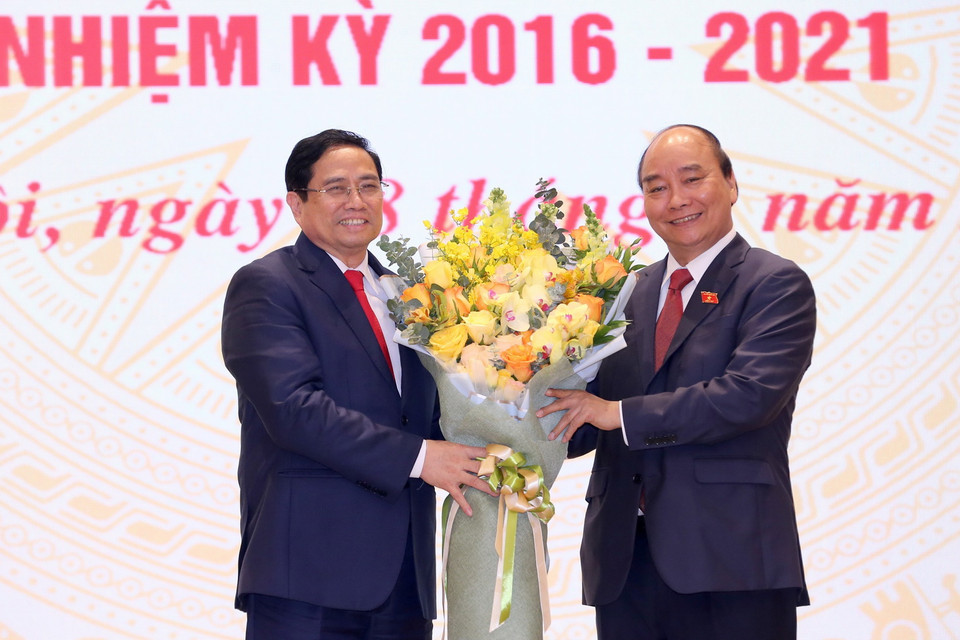  Chủ tịch nước Nguyễn Xuân Phúc, nguyên Thủ tướng Chính phủ tặng hoa chúc mừng Thủ tướng Chính phủ Phạm Minh Chính. (Ảnh: TTXVN)