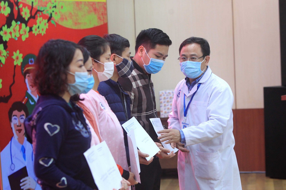 Đại diện gia đình các bệnh nhân nhận giấy chứng nhận ra viện. (Ảnh: An Đăng/TTXVN)