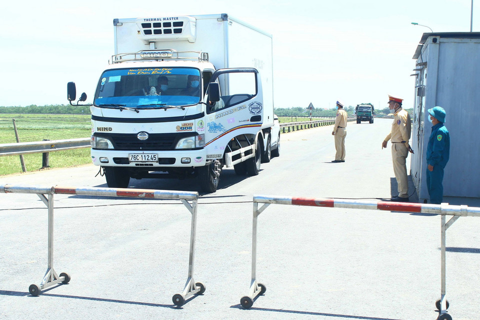  Cán bộ chiến sỹ Cảnh sát giao thông thành phố Vinh "căng mình" dưới nắng nóng để giải thích cho các phương tiện không được qua chốt kiểm soát tại đê xã Hưng Hòa, thành phố Vinh, tỉnh Nghệ An khi không đầy đủ các giấy tờ theo quy định. (Ảnh: Tá Chuyên/TTXVN)