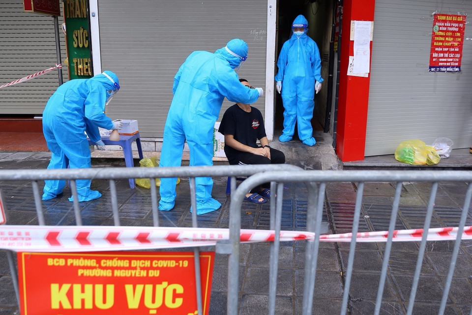 Người dân liên quan đến ca F0 ở số 21 Trần Nhân Tông được lấy mẫu xét nghiệm. (Ảnh: Hoàng Hiếu/TTXVN) 