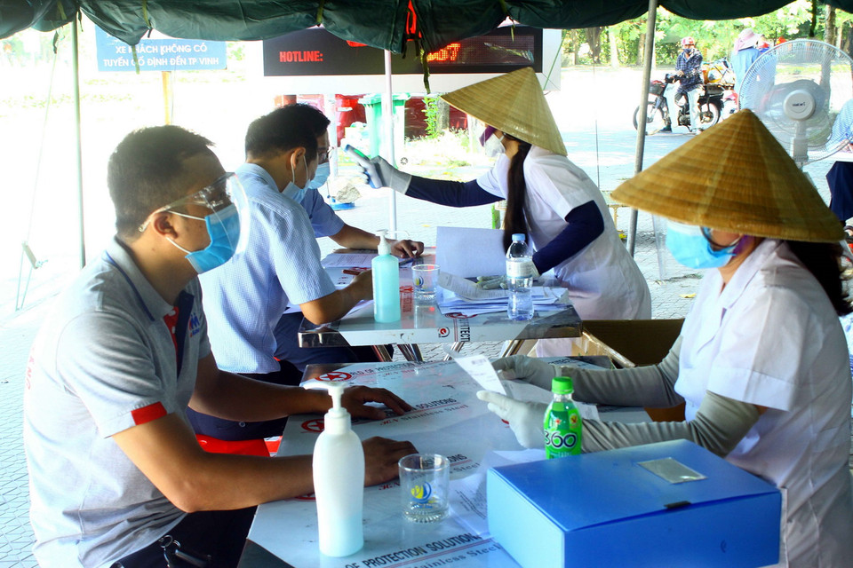  Các chủ phương tiện khai báo y tế khi đầy đủ các loại giấy tờ quy định để qua chốt kiểm soát cầu Bến Thủy. (Ảnh: Tá Chuyên/TTXVN)