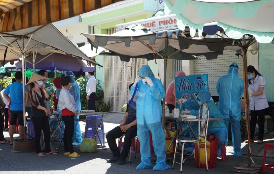 Lực lượng y tế tiến hành lấy mẫu xét nghiệm người dân trong hẻm bị phong tỏa. (Ảnh: TTXVN phát)