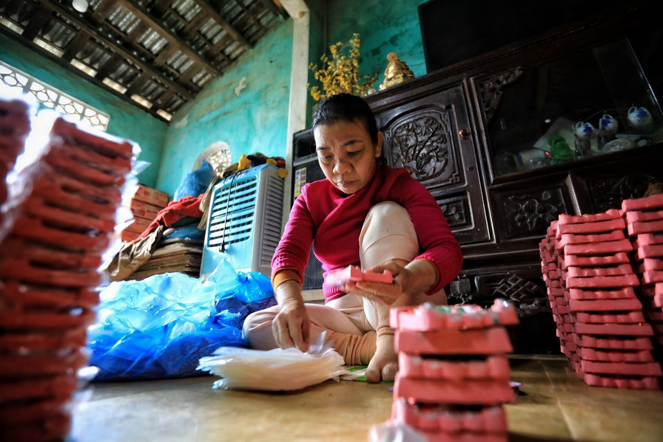 Tượng ông Công, ông Táo sẽ có 2 màu chính là đỏ sẫm do nhuộm sơn mài hoặc màu hồng, sau khi nung tượng được phủ một lớp sơn, trang trí và gắn kim tuyến. (Ảnh: Thành Đạt/TTXVN)