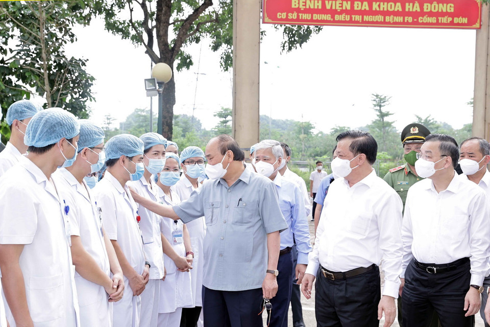 Chủ tịch nước Nguyễn Xuân Phúc động viên các nhân viên ý tế làm việc tại cơ sở thu dung, điều trị bệnh nhân mắc COVID-19 do Bệnh viện Đa khoa Hà Đông điều hành. (Ảnh: Thống Nhất/TTXVN) 