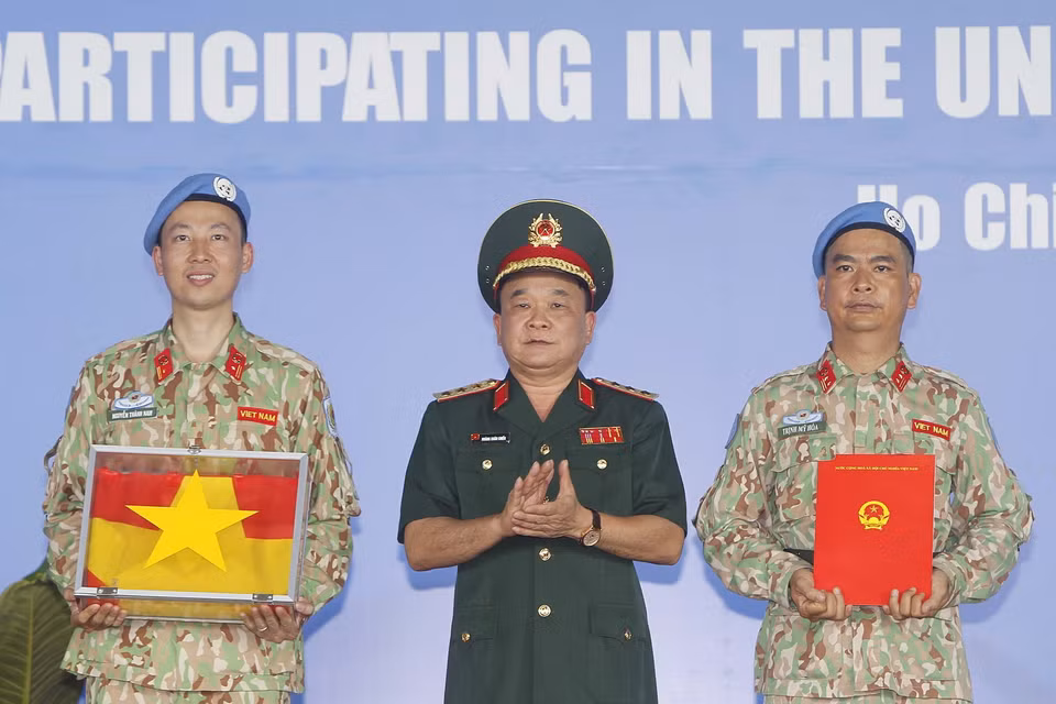  Thượng tướng Hoàng Xuân Chiến, Thứ trưởng Bộ Quốc phòng trao Quyết định của Chủ tịch nước và Quốc kỳ cho Bệnh viện dã chiến 2.3 trước khi lên đường làm nhiệm vụ. (Ảnh: Thanh Vũ/TTXVN)