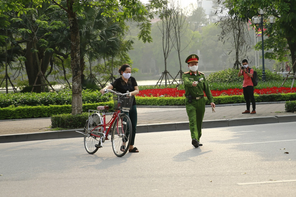 Công an quận Hoàn Kiếm lập chốt, yêu cầu người dân ở nhà, hạn chế tối đa ra ngoài tập thể dục tại khu vực Hồ Hoàn Kiếm. (Ảnh: Doãn Tấn/TTXVN)