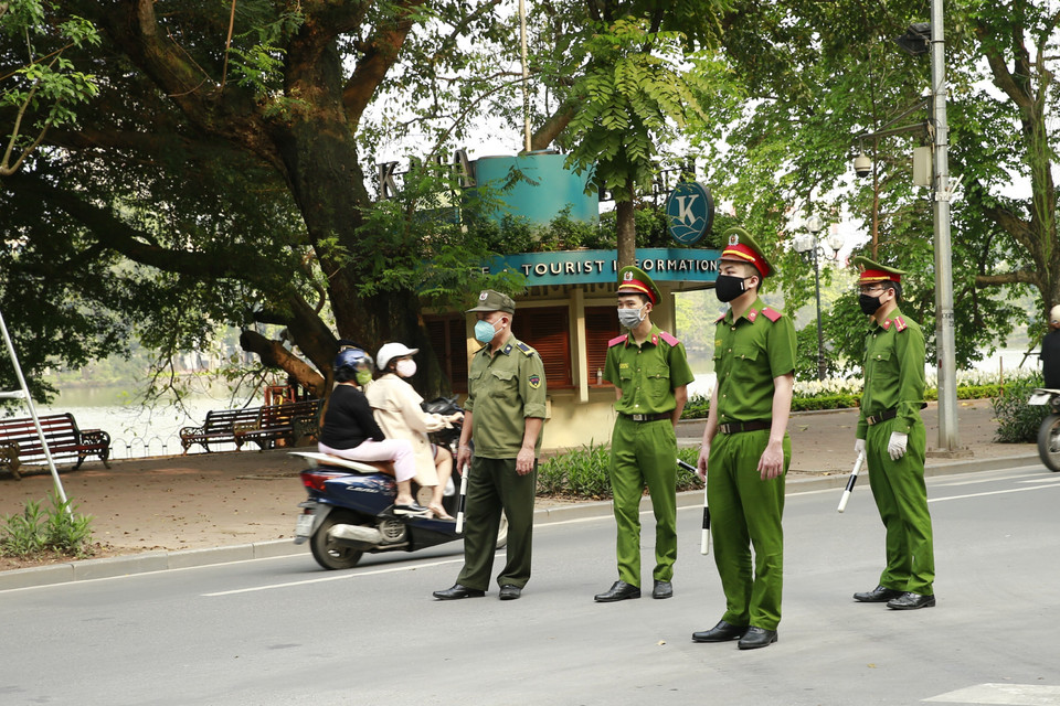Công an quận Hoàn Kiếm lập chốt, tuyên truyền người dân ở nhà, hạn chế tối đa ra ngoài tập thể dục tại khu vực Hồ Hoàn Kiếm. (Ảnh: Doãn Tấn/TTXVN)