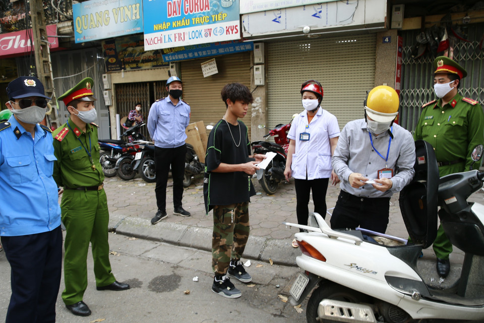 Tổ công tác của phường Đồng Nhân (quận Hai Bà Trưng, Hà Nội) xử phạt các trường hợp vi phạm không đeo khẩu trang ra đường. (Ảnh: Doãn Tấn/TTXVN)