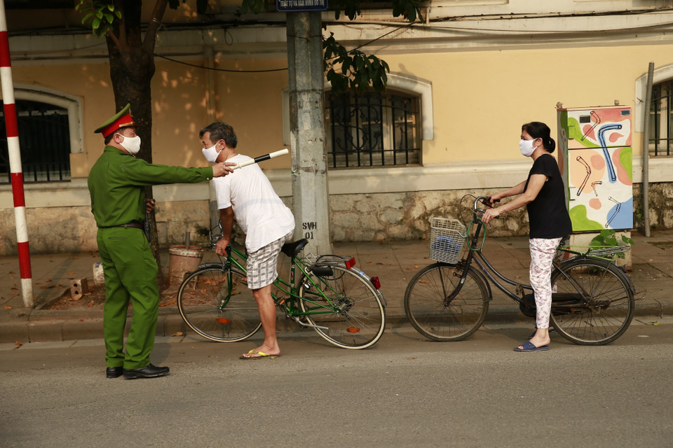 Công an quận Hoàn Kiếm lập chốt, tuyên truyền người dân ở nhà, hạn chế tối đa ra ngoài tập thể dục tại khu vực Hồ Hoàn Kiếm. (Ảnh: Doãn Tấn/TTXVN)