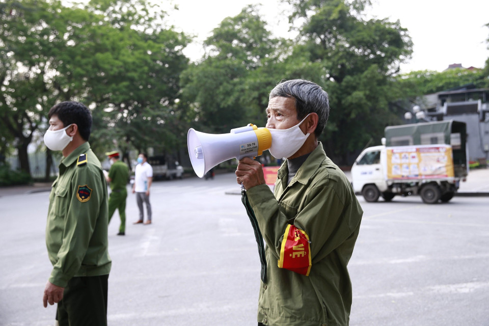 Đội tự quản Công an quận Hoàn Kiếm dùng loa tuyên truyền người dân ở nhà, hạn chế tối đa ra ngoài tại khu vực Hồ Hoàn Kiếm. (Ảnh: Doãn Tấn/TTXVN)