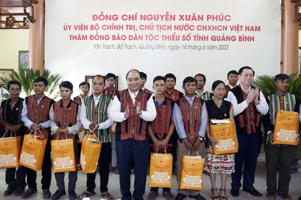 Chủ tịch nước Nguyễn Xuân Phúc tặng quà già làng, trưởng bản tại 2 xã Tân Trạch và Thượng Trạch. (Ảnh: Thống Nhất/TTXVN)