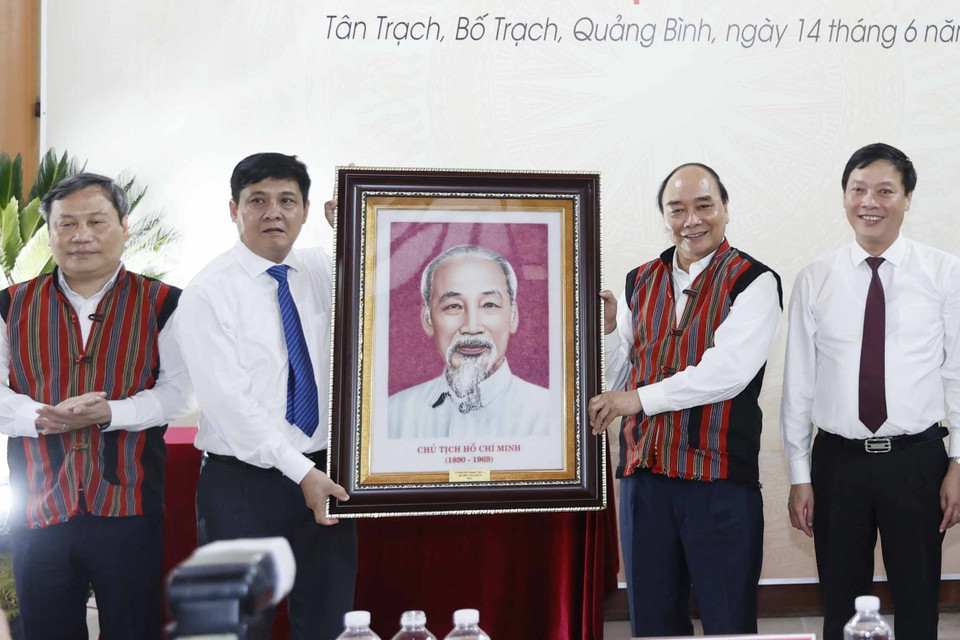 Chủ tịch nước Nguyễn Xuân Phúc tặng phẩm lưu niệm cho đại diện lãnh đạo huyện Bố Trạch, tỉnh Quảng Bình. (Ảnh: Thống Nhất/TTXVN)