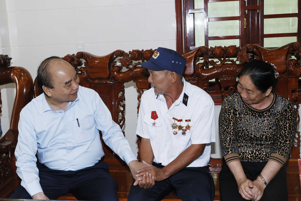 Chủ tịch nước Nguyễn Xuân Phúc thăm, tặng quà thương binh Nguyễn Thống tại thôn Mỹ Cảnh, xã Bảo Ninh, thành phố Đồng Hới. (Ảnh: Thống Nhất/TTXVN)