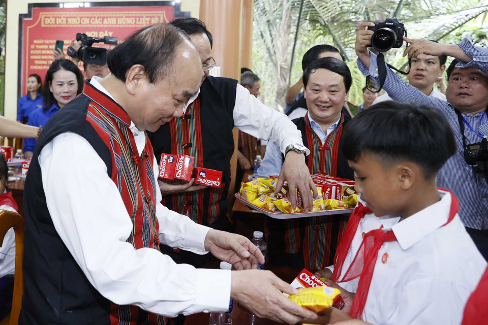 Chủ tịch nước Nguyễn Xuân Phúc tặng quà cho các em học sinh dân tộc thiểu số tại 2 xã Tân Trạch và Thượng Trạch. (Ảnh: Thống Nhất/TTXVN)