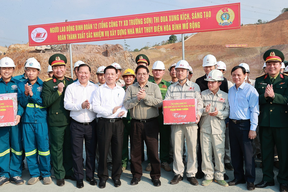 Thủ tướng Phạm Minh Chính tặng quà cho các kỹ sư, công nhân thi công mở rộng Nhà máy Thủy điện Hòa Bình. (Ảnh: Dương Giang/TTXVN)