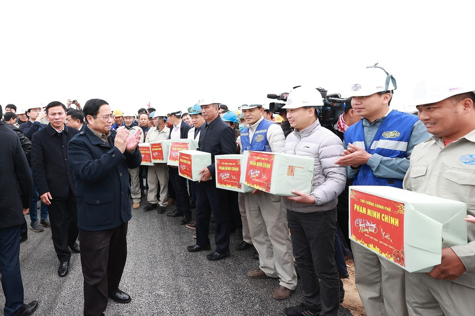 Thủ tướng Phạm Minh Chính động viên, chúc mừng năm mới tới kỹ sư, công nhân thi công nút giao Đông Xuân thuộc dự án thành phần cao tốc Mai Sơn-Quốc lộ 45. (Ảnh: Dương Giang/TTXVN)
