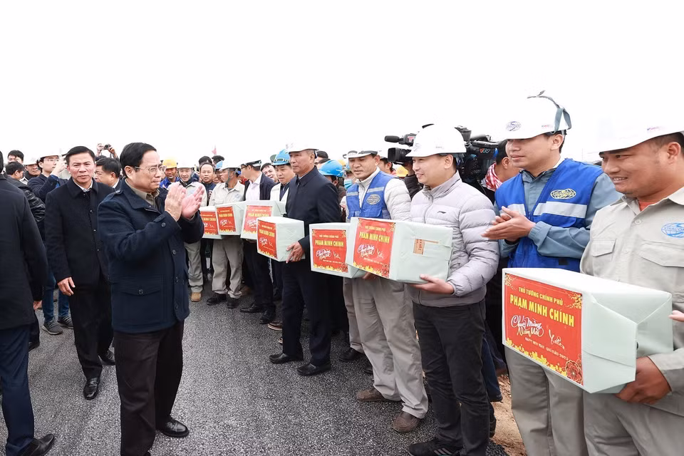 Thủ tướng Phạm Minh Chính động viên, chúc mừng năm mới tới kỹ sư, công nhân thi công nút giao Đông Xuân thuộc dự án thành phần cao tốc Mai Sơn-Quốc lộ 45. (Ảnh: Dương Giang/TTXVN)