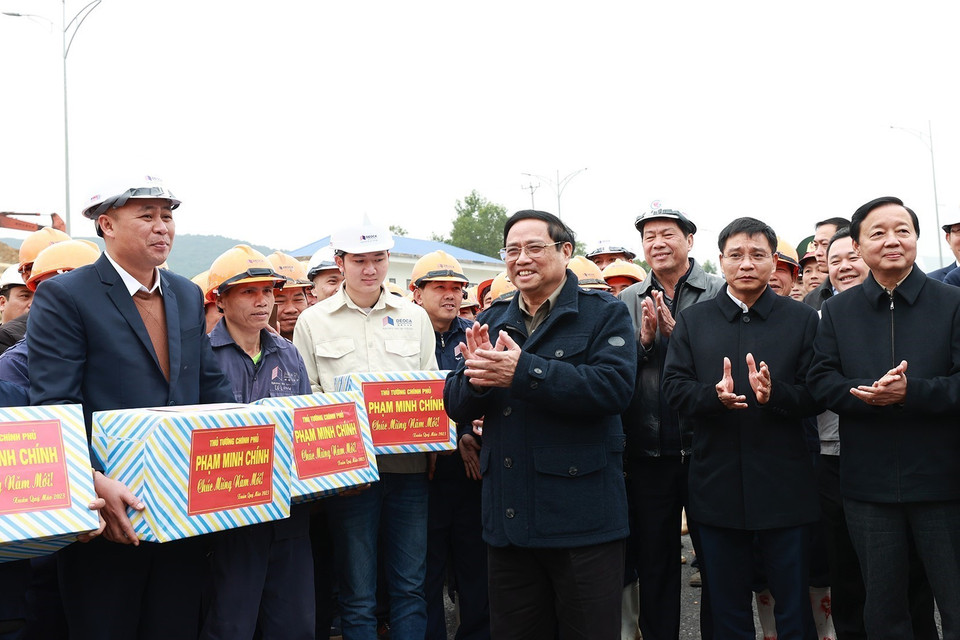 Thủ tướng Phạm Minh Chính động viên, chúc mừng năm mới tới kỹ sư, công nhân thi công hầm Thung Thi. (Ảnh: Dương Giang/TTXVN)