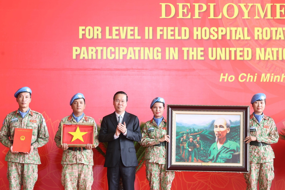 Chủ tịch nước Võ Văn Thưởng trao quyết định và tặng cờ Tổ quốc cùng bức tranh 'Bác đang cùng chúng cháu hành quân' cho các lực lượng lên đường làm nhiệm vụ. (Ảnh: Thống Nhất/TTXVN)