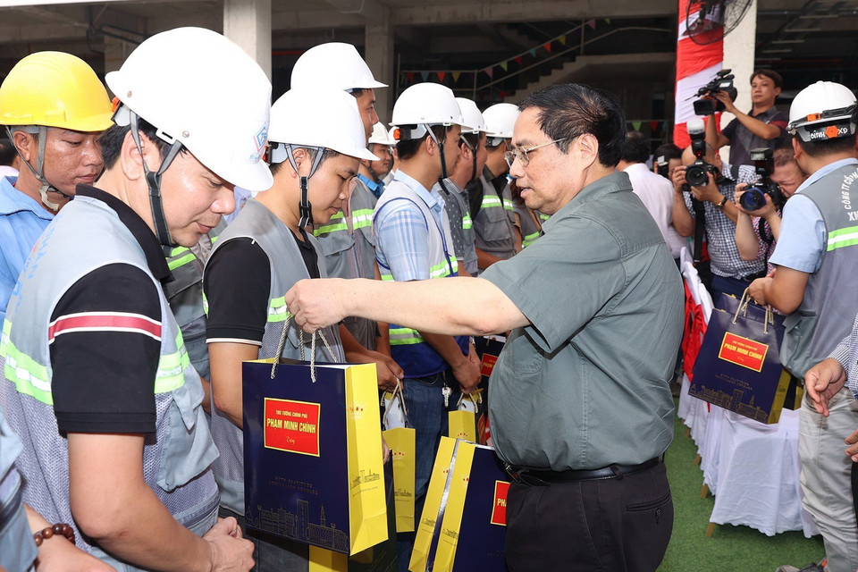 Thủ tướng Phạm Minh Chính tặng quà công nhân thi công dự án xây dựng mới Bệnh viện Đa khoa khu vực Thủ Đức. (Ảnh: Dương Giang/TTXVN)