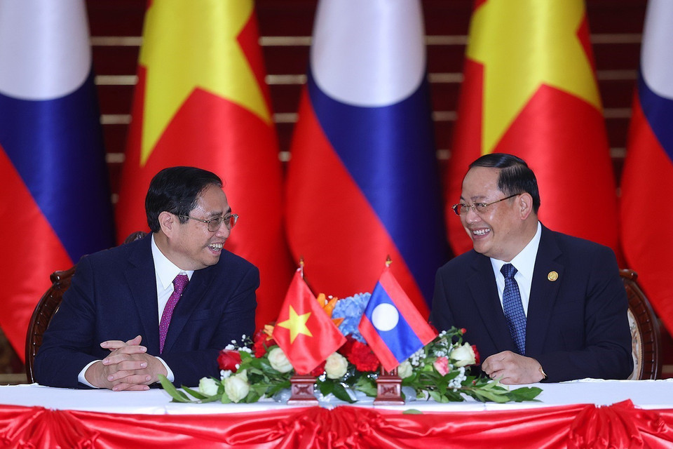 Thủ tướng Phạm Minh Chính và Thủ tướng Lào Sonexay Siphandone trao đổi tại lễ ký các văn kiện hợp tác giữa hai nước Việt Nam-Lào. (Ảnh: Dương Giang/TTXVN)