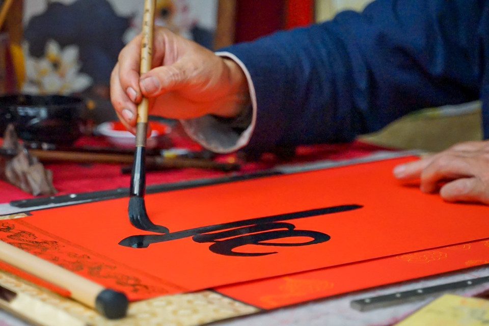 Nét chữ thư pháp uốn lượn của một ông đồ ở Hội chữ Xuân Quý Mão 2023 ngày mùng 2 Tết. (Ảnh: Khánh Hòa/TTXVN)