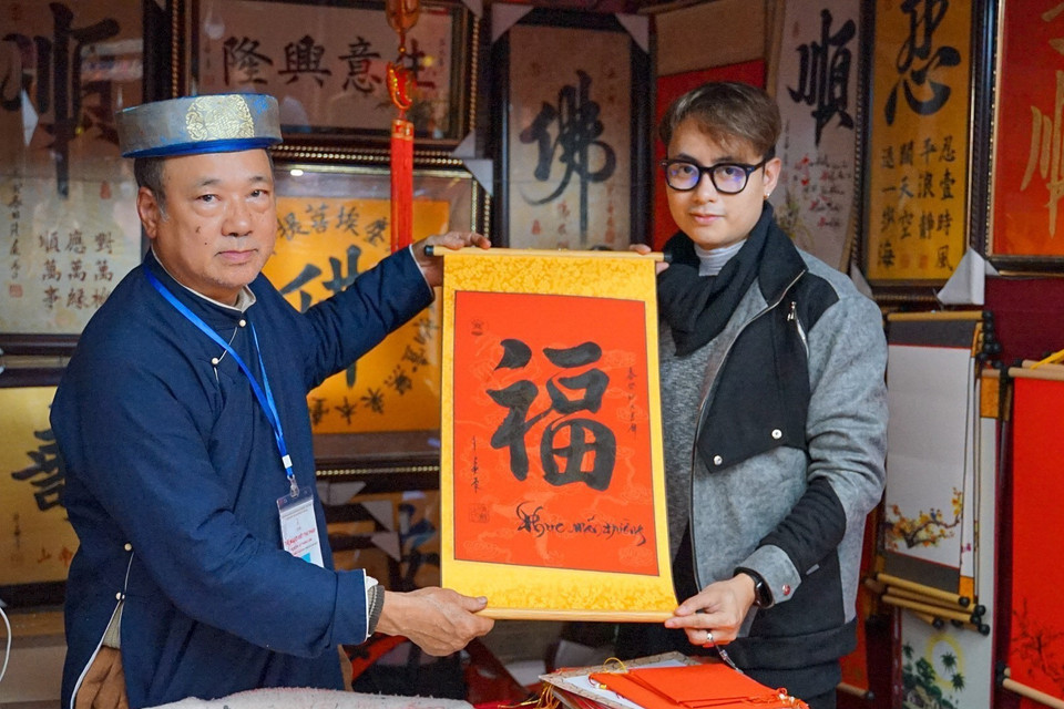 Một bạn trẻ thích thú nhận chữ mới xin ở Hội chữ Xuân Quý Mão 2023. (Ảnh: Khánh Hòa/TTXVN)