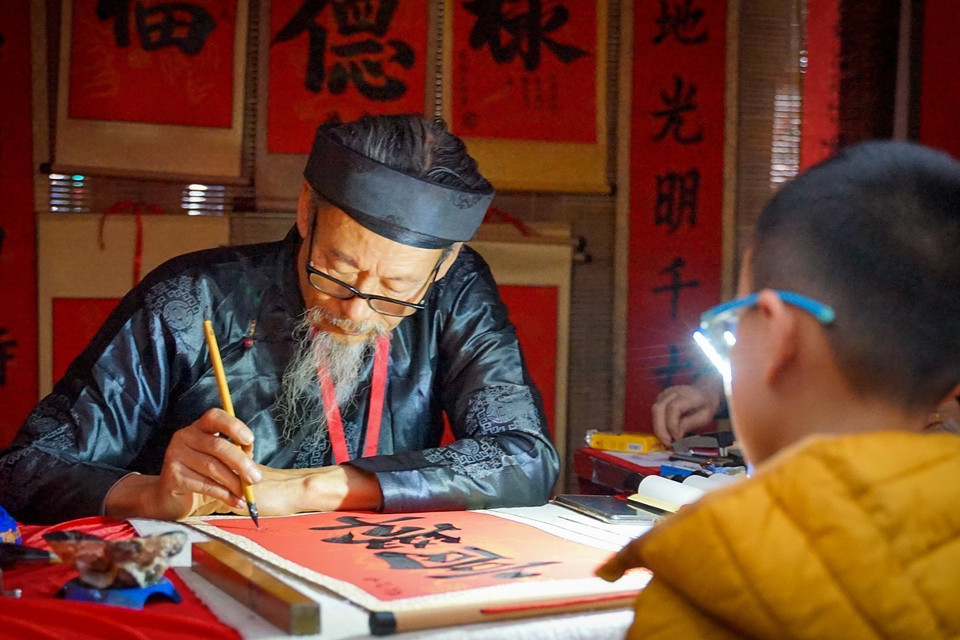 Một bạn nhỏ xin chữ cầu mong năm mới đạt được nhiều thành tích tốt trong học tập ở Hồ Văn-Văn Miếu Quốc Tử Giám. (Ảnh: Khánh Hòa/TTXVN)