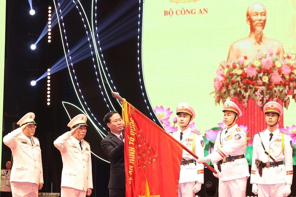 Chủ tịch nước Võ Văn Thưởng gắn Huân chương Bảo vệ Tổ quốc hạng Nhất lên lá cờ truyền thống Xây dựng lực lượng công an nhân dân. (Ảnh: Trí Dũng/TTXVN)