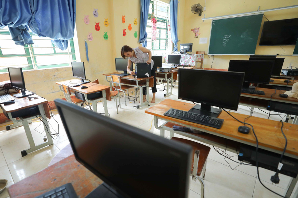 Giáo viên lắp đặt máy tính được mượn từ một số đơn vị trên địa bàn kịp thời phục vụ cho năm học mới. (Ảnh: Thanh Tùng/TTXVN)