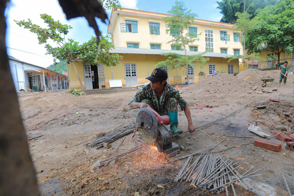 Công tác khắc phục hậu quả mưa lũ tại trường. (Ảnh: Thanh Tùng/TTXVN)