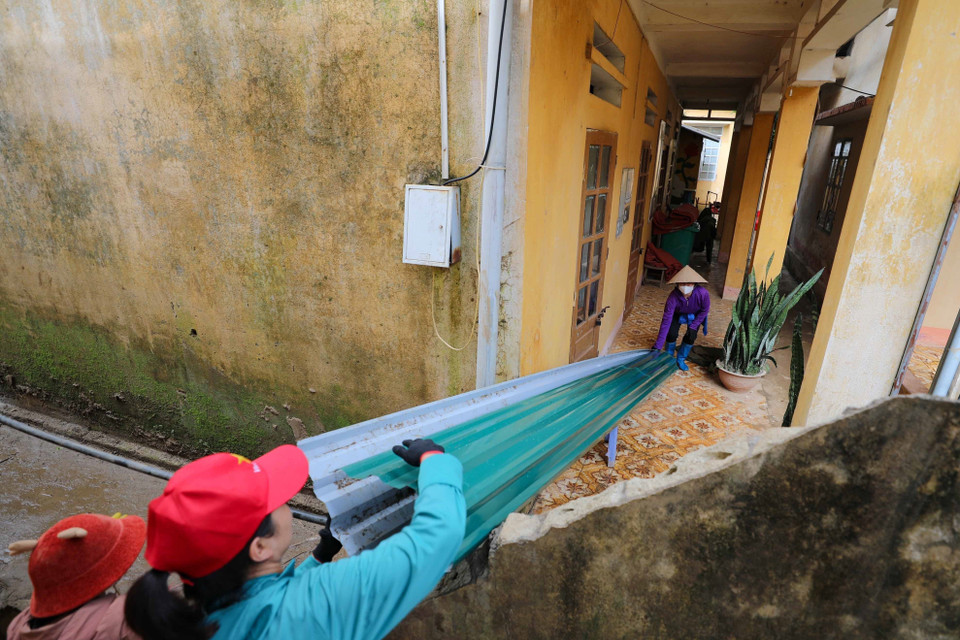 Giáo viên cùng các lực lượng trợ giúp đang khẩn trương dọn dẹp, sửa chữa trường, lớp để học sinh có thể đón năm học mới đúng kế hoạch. (Ảnh: Thanh Tùng/TTXVN)