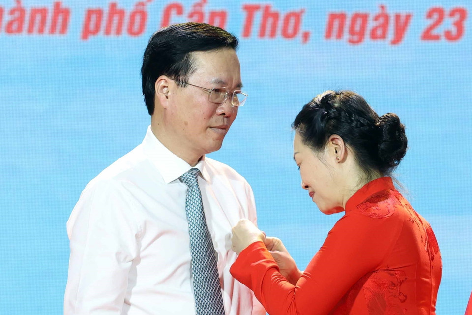 Bà Bùi Thị Hòa - Chủ tịch Hội Chữ thập Đỏ Việt Nam gắn Huy hiệu Chữ thập Đỏ và tặng hoa chúc mừng Chủ tịch nước Võ Văn Thưởng làm Chủ tịch danh dự Hội Chữ thập Đỏ Việt Nam. (Ảnh: Thống Nhất/TTXVN)