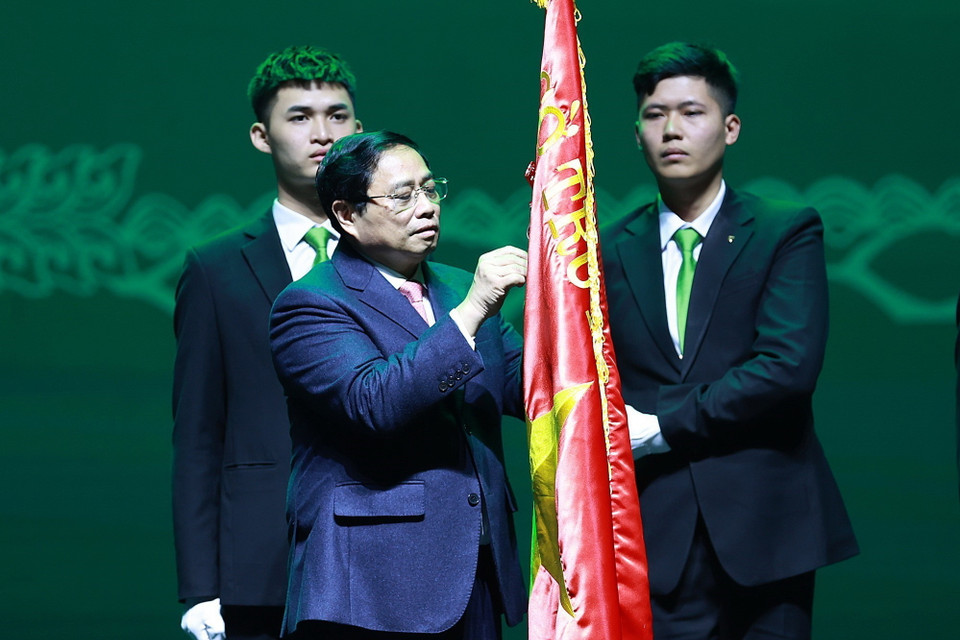 Thủ tướng Phạm Minh Chính gắn Danh hiệu Anh hùng Lao động lên cờ truyền thống Ngân hàng thương mại cổ phần Ngoại thương Việt Nam. (Ảnh: Dương Giang/TTXVN)