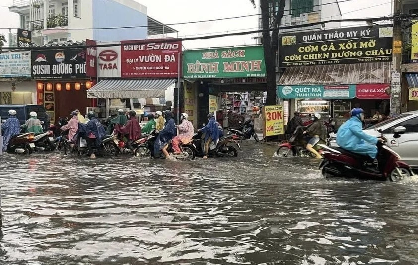 Nước ngập gần nửa bánh xe trên đường Lê Văn Thọ, quận Gò Vấp. (Ảnh: Hồng Giang/TTXVN)