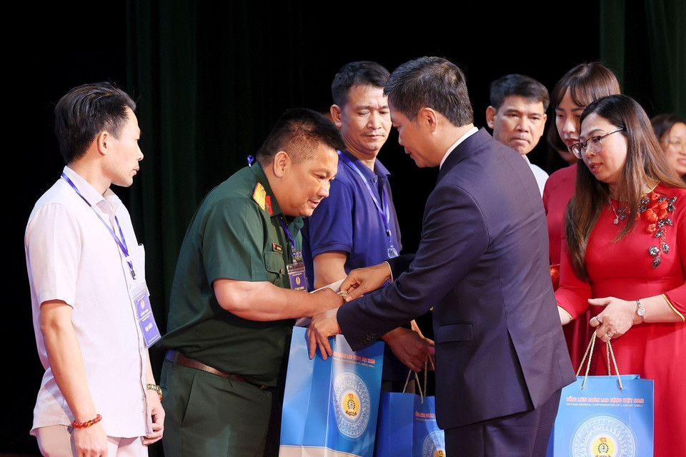 Trưởng Ban Kinh tế Trung ương Trần Tuấn Anh trao quà cho các công nhân có hoàn cảnh khó khăn. (Ảnh: Dương Giang/TTXVN)