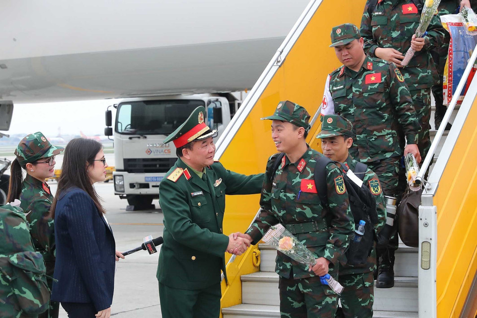 Thượng tướng Hoàng Xuân Chiến, Thứ trưởng Bộ Quốc phòng ra tận chân cầu thang máy bay tặng hoa đón các thành viên trong đoàn. (Ảnh: Trọng Đức/TTXVN)