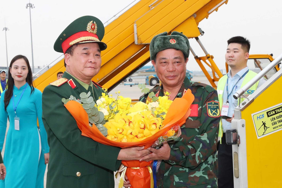 Thượng tướng Hoàng Xuân Chiến, Thứ trưởng Bộ Quốc phòng ra tận chân cầu thang máy bay tặng hoa đón các thành viên trong đoàn. (Ảnh: Trọng Đức/TTXVN)