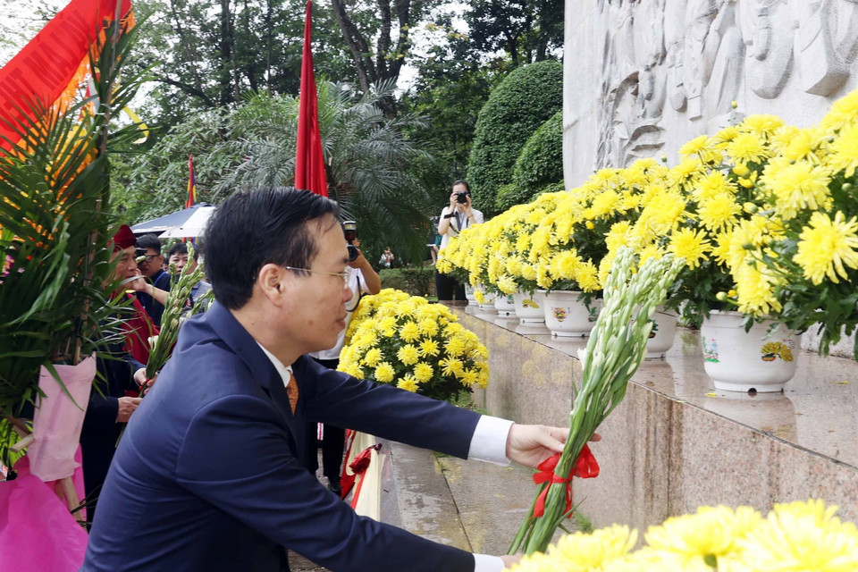 Chủ tịch nước Võ Văn Thưởng dâng hoa tưởng niệm Chủ tịch Hồ Chí Minh tại bức phù điêu 'Bác Hồ nói chuyện với cán bộ, chiến sỹ Đại đoàn quân Tiên Phong.' (Ảnh: Thống Nhất/TTXVN)