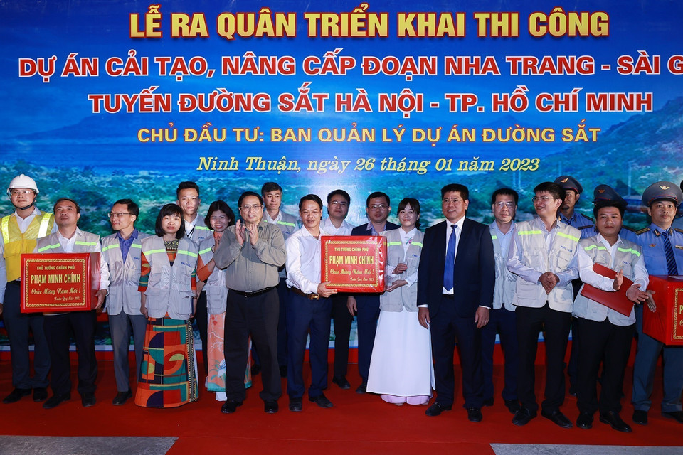 Thủ tướng Phạm Minh Chính tặng quà cho cán bộ, kỹ sư, công nhân viên tham gia dự án. (Ảnh: Dương Giang/TTXVN)