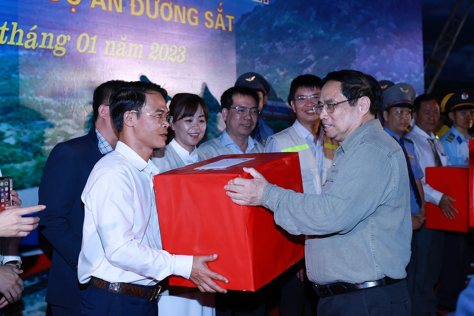 Thủ tướng Phạm Minh Chính tặng quà cho cán bộ, kỹ sư, công nhân viên tham gia dự án. (Ảnh: Dương Giang/TTXVN)