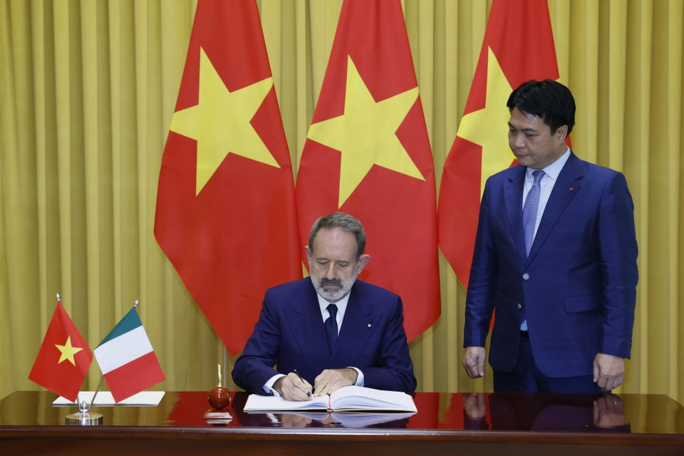 Đại sứ Cộng hòa Italy Marco Della Seta viết lưu bút. (Ảnh: Thống Nhất/TTXVN)