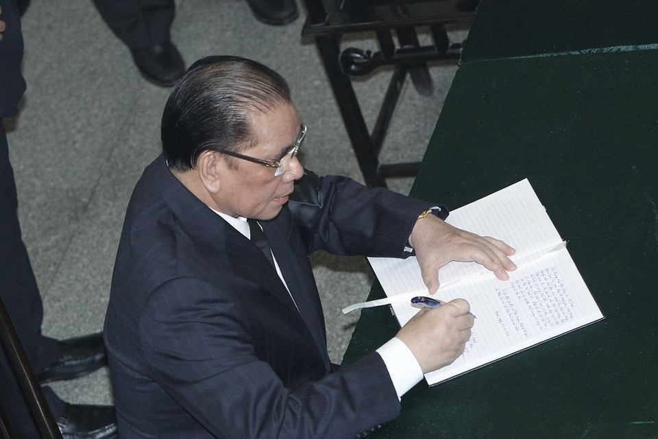 Nguyên Tổng Bí thư Nông Đức Mạnh ghi sổ tang tưởng nhớ nguyên Tổng Bí thư Đỗ Mười. (Ảnh: TTXVN)