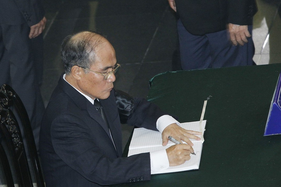 Nguyên Chủ tịch Quốc hội Nguyễn Sinh Hùng ghi sổ tang tưởng nhớ nguyên Tổng Bí thư Đỗ Mười. (Ảnh: TTXVN)