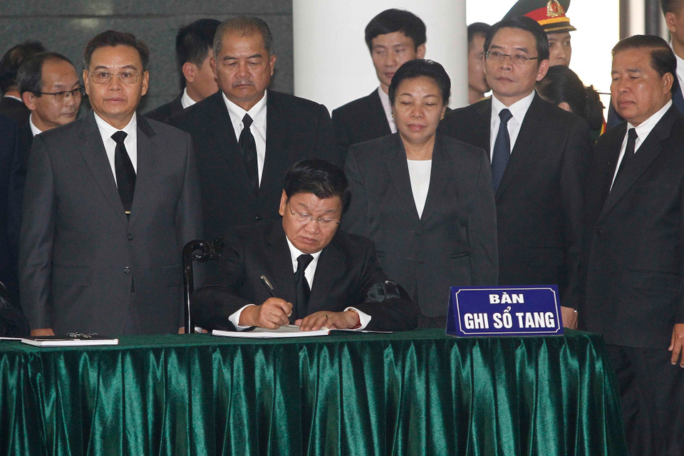 Thủ tướng Lào Thongloun Sisoulith ghi sổ tang viếng nguyên Tổng Bí thư Đỗ Mười. (Ảnh: TTXVN)