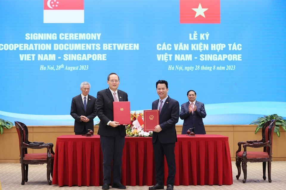 Thủ tướng Phạm Minh Chính và Thủ tướng Singapore Lý Hiển Long chứng kiến ký Ý định thư giữa Bộ Tài nguyên và Môi trường Việt Nam và Bộ Công Thương Singapore về việc tiếp tục thực hiện Bản ghi nhớ hợp tác theo Điều 6 Thỏa thuận Paris. (Ảnh: Dương Giang/TTXVN)